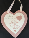 Close up of double heart plaque "a little princess sleeps here"